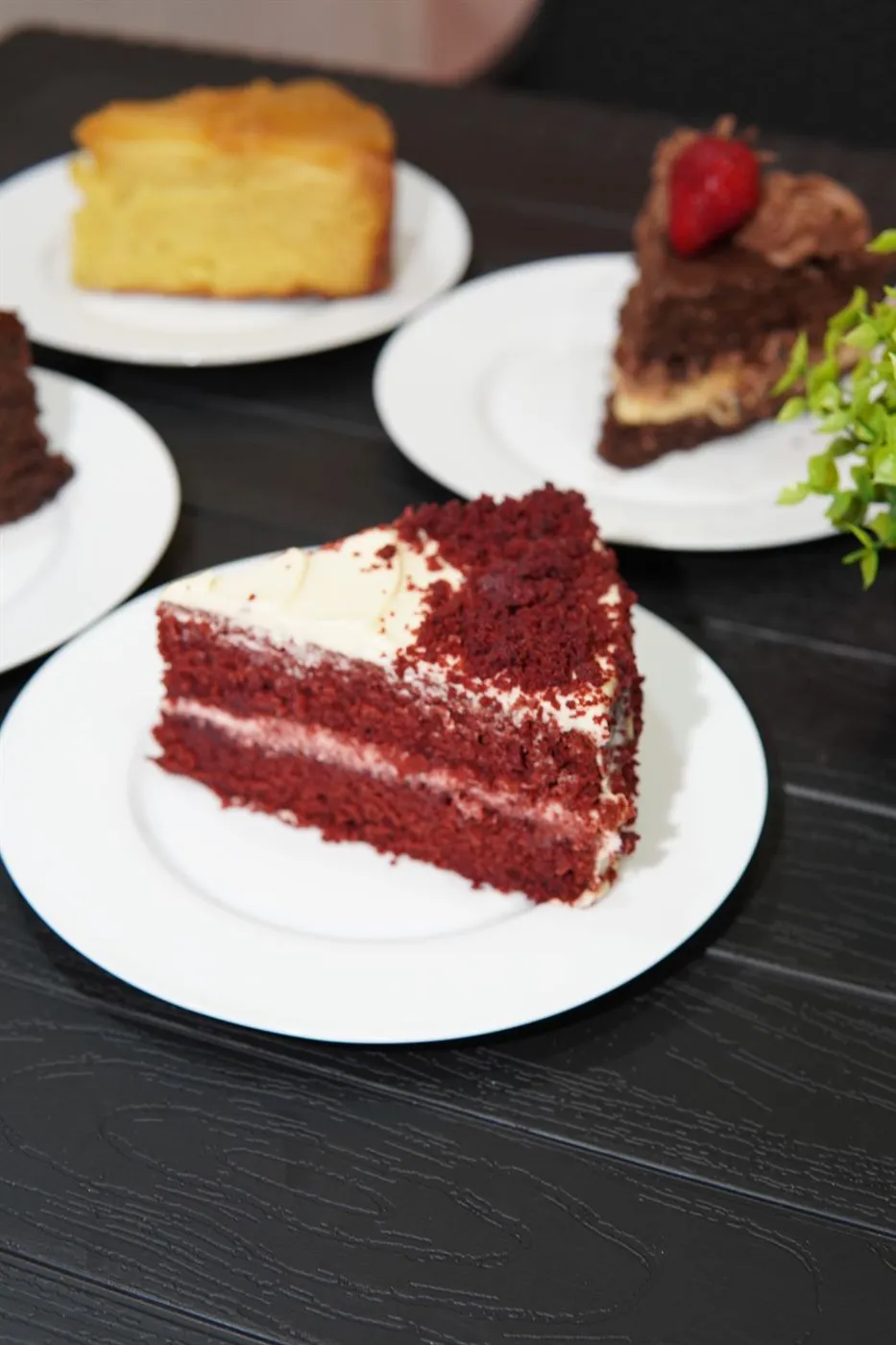 Mesa con porciones de red velvet, chocolate y piña